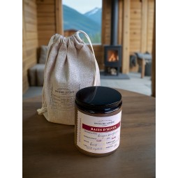 Bougie artisanale parfumée aux baies rouges, présentée dans une ambiance chaleureuse et hivernale avec cheminée en fond.
